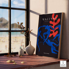 Matisse Art Prints -  Dance Blue Figures Poster displayed in a bright interior by a beach view.