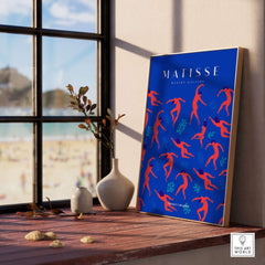 Matisse Art Prints -  Dancing Figures Pattern Red Blue Poster displayed in a bright room with a beach view.