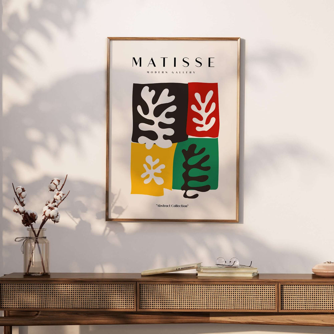 Matisse art print featuring four color blocks with abstract leaves, black, red, yellow, and green on wall.