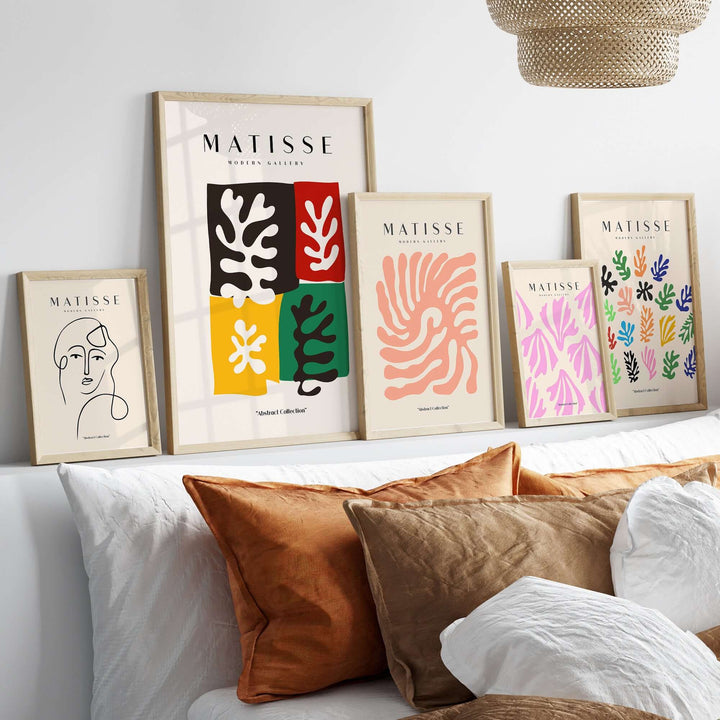 Matisse art prints displayed on a shelf, featuring abstract leaves and portraits in colorful frames.