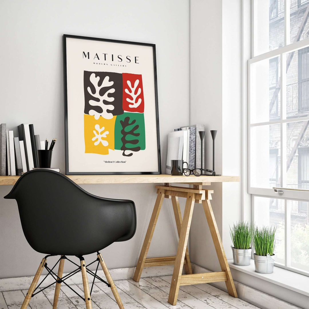 Matisse art print featuring bold color blocks and abstract leaves in a modern workspace.