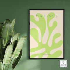 Matisse Art Prints - Lime Green Abstract Coral Shape Poster displayed on a green wall with tropical leaves.