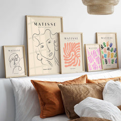 Matisse Art Prints -  Line Art Ladies Face with Wavy Hair Minimalist Poster displayed among other artworks on a wall.
