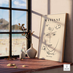 Matisse Art Prints -  Line Art Face Curly Hair Minimalist Poster displayed in a sunlit room with a beach view.