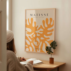 Matisse Art Prints - Orange Abstract Coral Pattern Poster displayed on a wall with a person reading nearby.