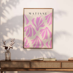 Matisse Art Prints - Pink Abstract Shapes Pattern Poster displayed on a wall above a wooden table with decor.