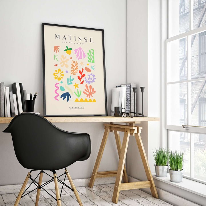 Matisse art print featuring playful abstract shapes in a stylish workspace, showcasing creativity and color.