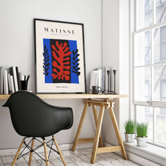 Matisse Art Prints -  Red Coral Black Leaves Blue Frame Poster displayed in a modern workspace with natural light.