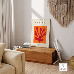 Matisse Art Prints - Red Leaf Abstract Orange Square Poster displayed on a wooden table in a cozy setting.