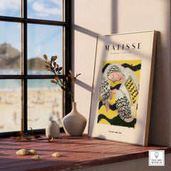 Matisse Art Prints - Resting Woman Patterned Blouse Yellow displayed in a bright room with scenic beach view.