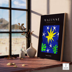 Matisse Art Prints - Stars Leaves Night Sky Abstract Print displayed in a gallery by a window overlooking a beach.