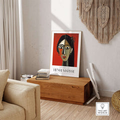 Matisse Art Prints - Stylized Woman Portrait Red Wall Art displayed in a stylish interior with wooden decor.