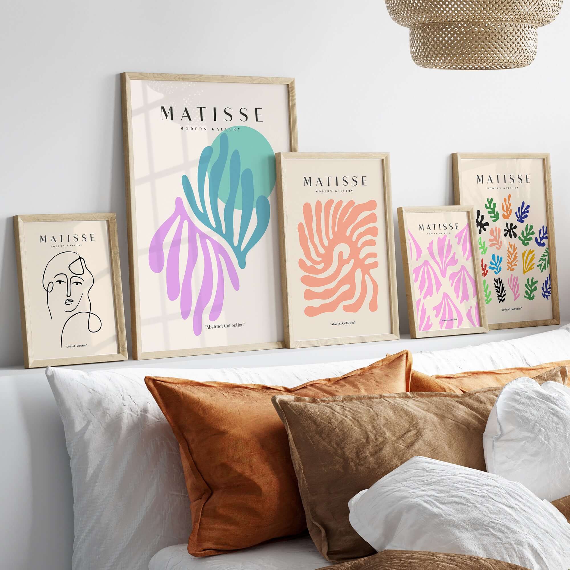 Matisse Art Prints -Teal Pink Abstract Leaves Sun Poster displayed on a wall above a couch with decorative pillows.