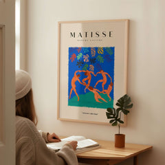Matisse Art Prints - The Dance Figures Abstract Sky Poster displayed on a wall beside a person reading.