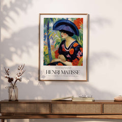 Matisse Art Prints - Woman with Blue Hat Garden Poster displayed in a stylish interior with a wooden console.