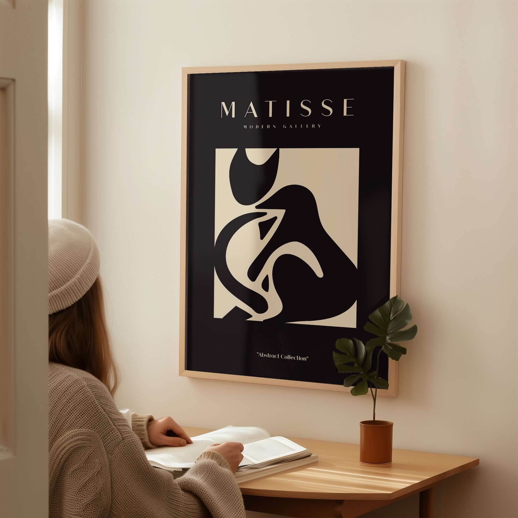 Matisse Art Prints - Black Beige Abstract Composition Poster displayed on a wall with a person reading nearby.