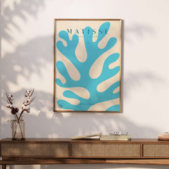 Matisse Art Prints -  Blue Coral Abstract Botanical Art Print Poster displayed on a wooden table with plants.