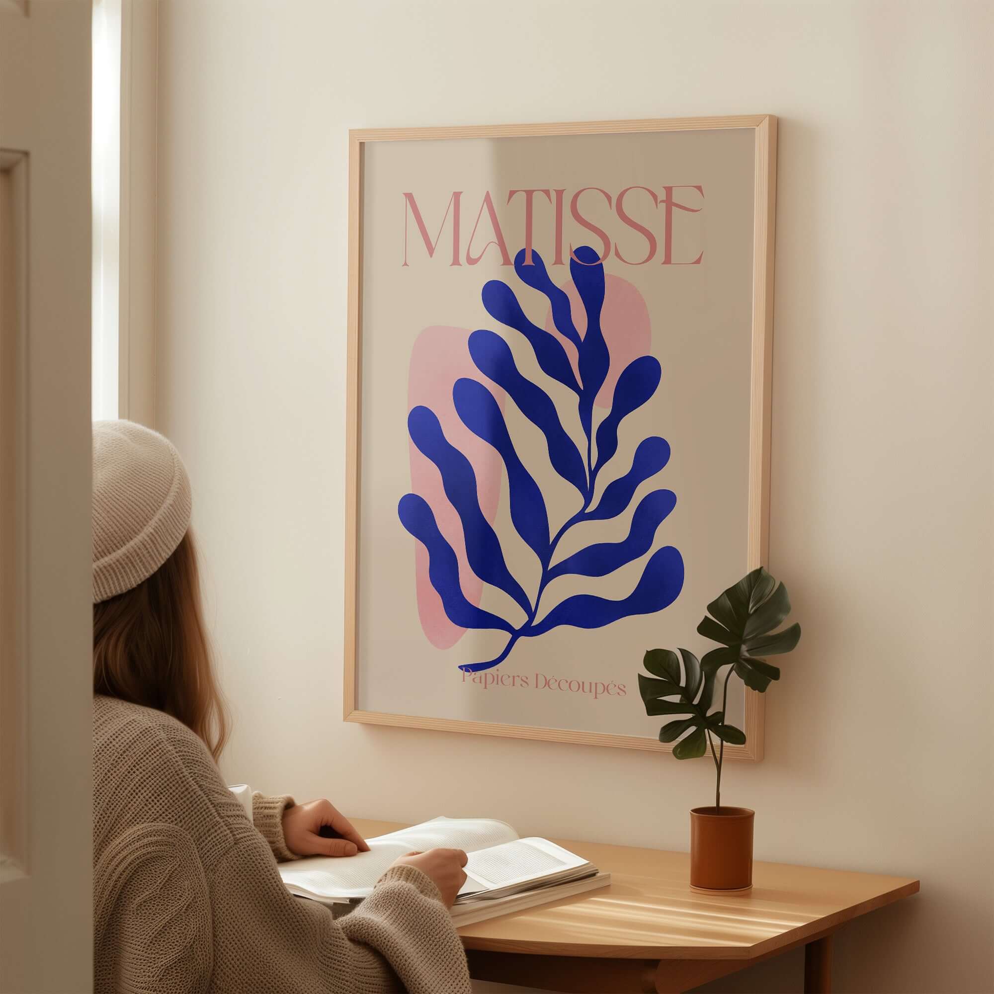 Matisse Blue Leaf Abstract Papiers Découpés Wall Art Print displayed in a cozy room, featuring a prominent blue leaf design.