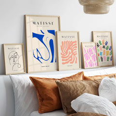 Matisse Art Prints - Blue Nude Abstract Cut Out Wall Art displayed on a shelf with decorative pillows.