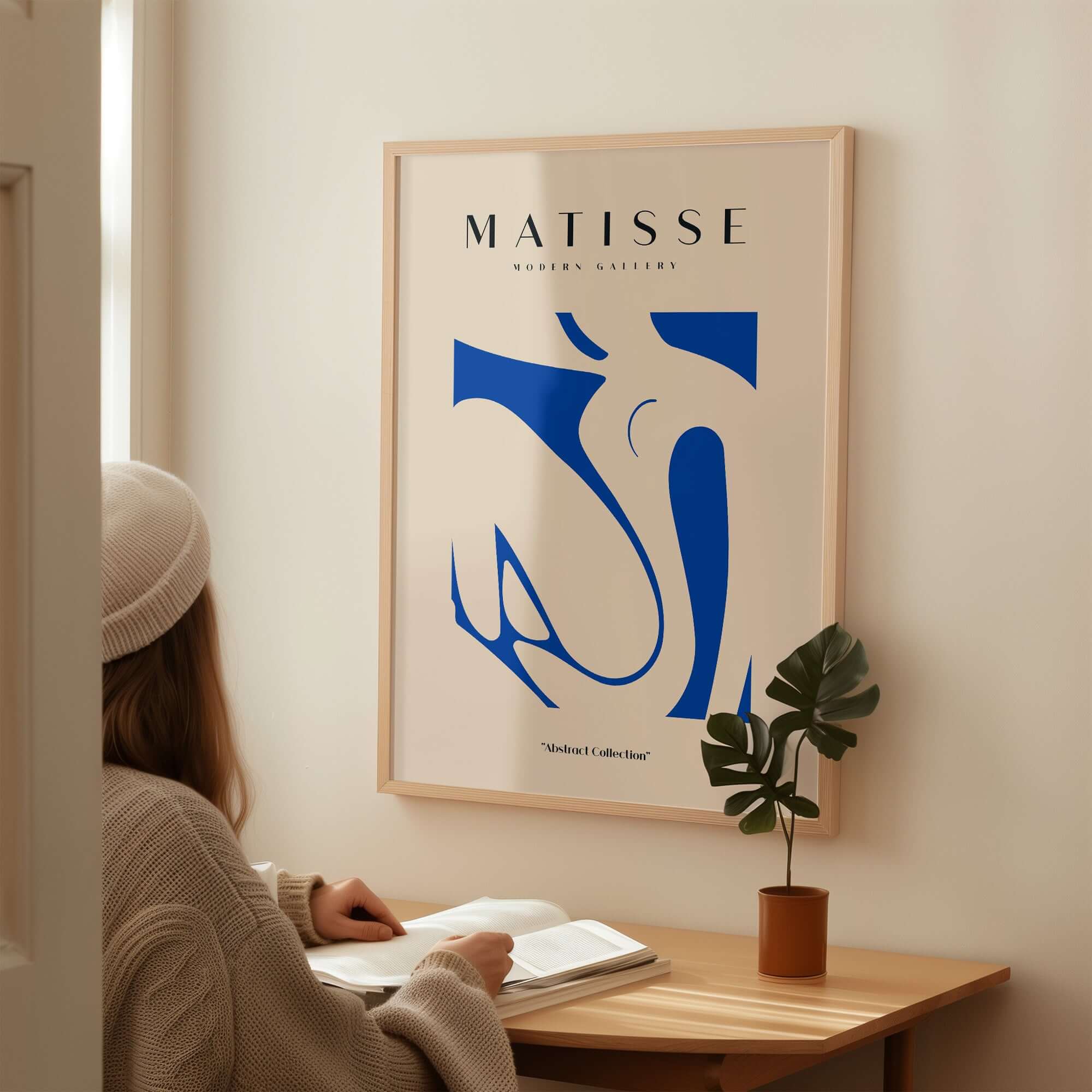 Matisse Art Prints - Blue Nude Abstract Cut Out Wall Art displayed in a cozy interior setting with a person reading.