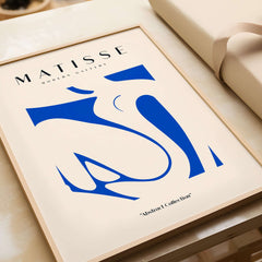 Matisse Art Prints - Blue Nude Abstract Cut Out Wall Art framed on table, featuring blue abstract cut-out design.