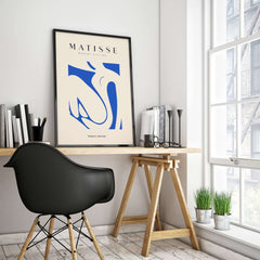 Matisse Art Prints - Blue Nude Abstract Cut Out Wall Art displayed in a stylish workspace with plants and books.