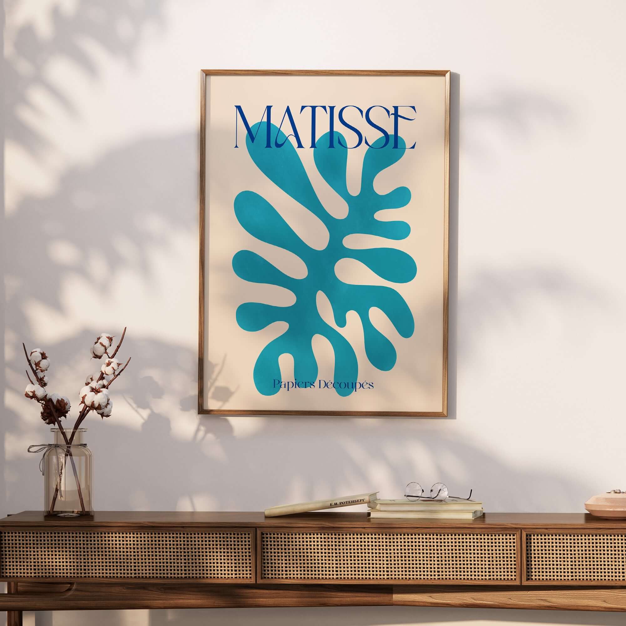 Matisse Cyan Blue Abstract Shape Papiers Découpés Poster displayed on a wall above a wooden console table.