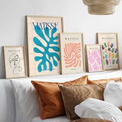 Matisse Cyan Blue Abstract Shape Papiers Découpés Poster framed in a modern living room display with decorative pillows.