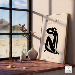 Matisse Art Prints - Figurative Lady Poster Art displayed on a shelf near a window with beach view.