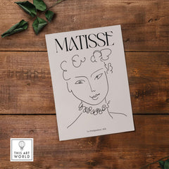 Matisse Art Print La Pompadour 1951 Minimalist Line Drawing Poster displayed on rustic wooden background.
