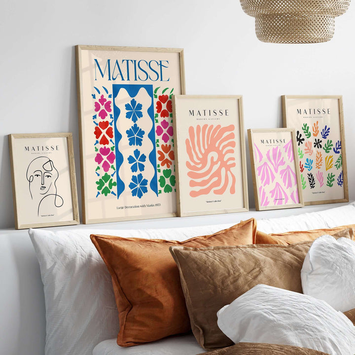 Gallery wall displaying Matisse art prints with vibrant floral designs and a minimalist face drawing.