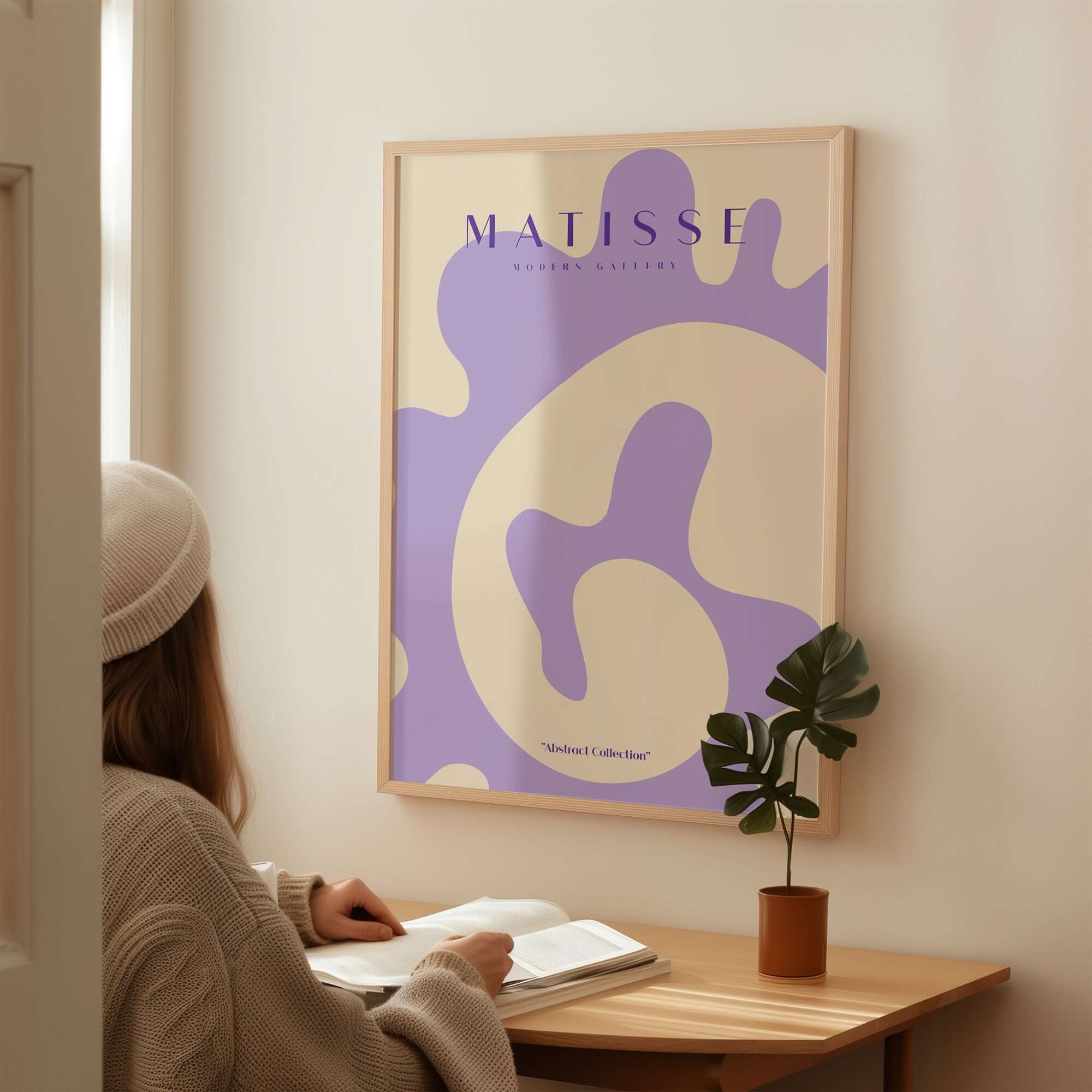 Matisse Art Prints -   Lavender Abstract Fluid Organic Shape Poster displayed in a cozy room with a plant.
