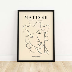 Matisse Art Prints -  Line Art Ladies Face with Wavy Hair Minimalist Poster framed on a beige wall.