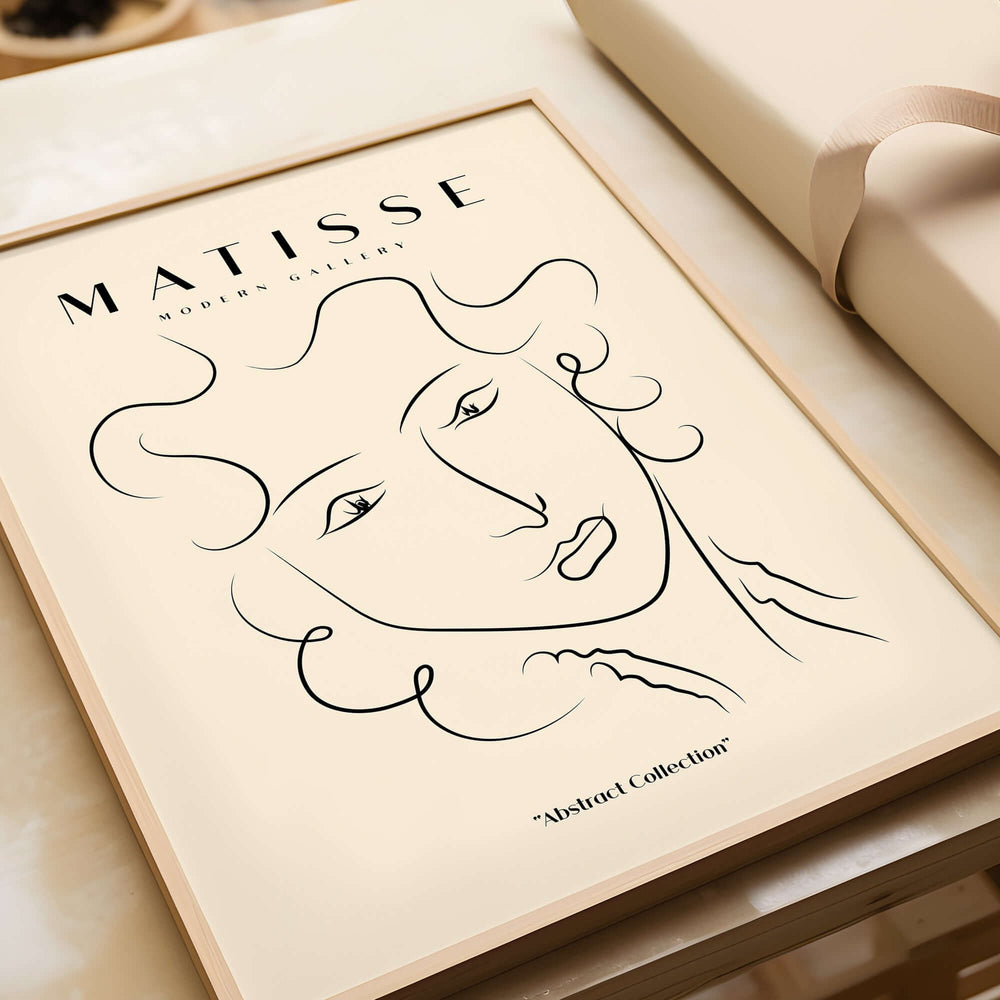 Matisse Art Prints -  Line Art Ladies Face with Wavy Hair Minimalist Poster displayed in a wooden frame against a beige background.
