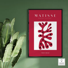 Matisse Art Prints - Red Coral Abstract Black Diamonds Poster framed on a green wall with tropical plant.