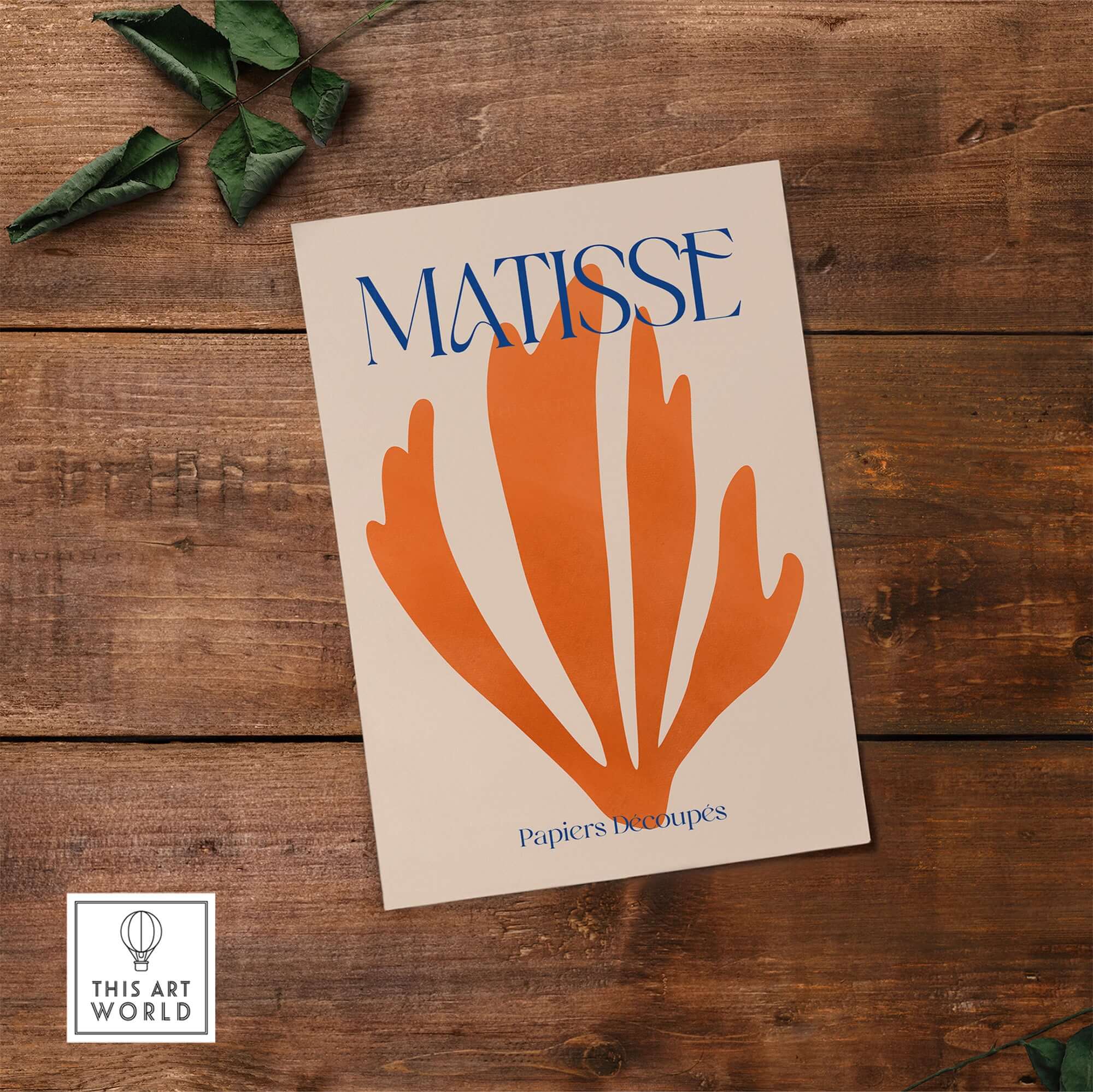 Matisse Papiers Découpés Orange Abstract Botanical Cut Out Art Print on wooden surface with green leaves