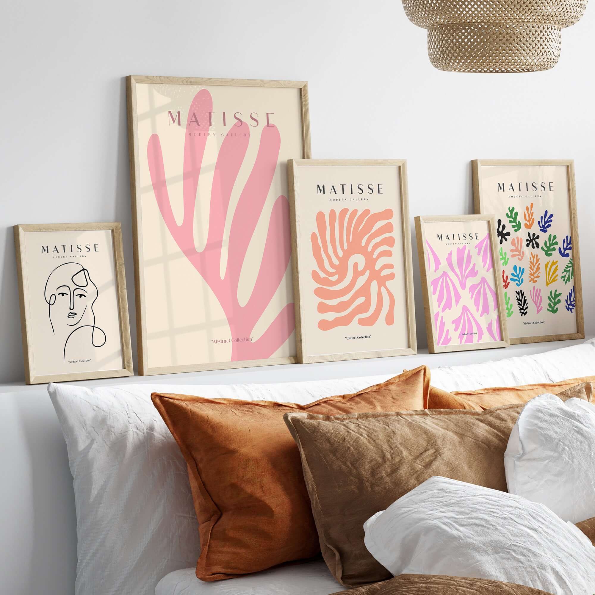 Matisse Art Prints - Pink Coral Leaf Abstract Botanical Poster displayed on a wall above a cozy bed with decorative cushions.