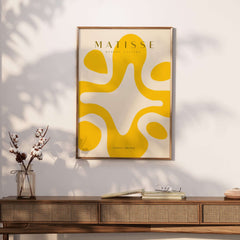 Matisse Art Prints -   Yellow Abstract Fluid Shape Poster displayed in a stylish interior setting with bright yellow designs.