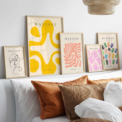 Matisse Art Prints - Yellow Abstract Fluid Shape Poster displayed on wall among other framed artworks in a modern setting.