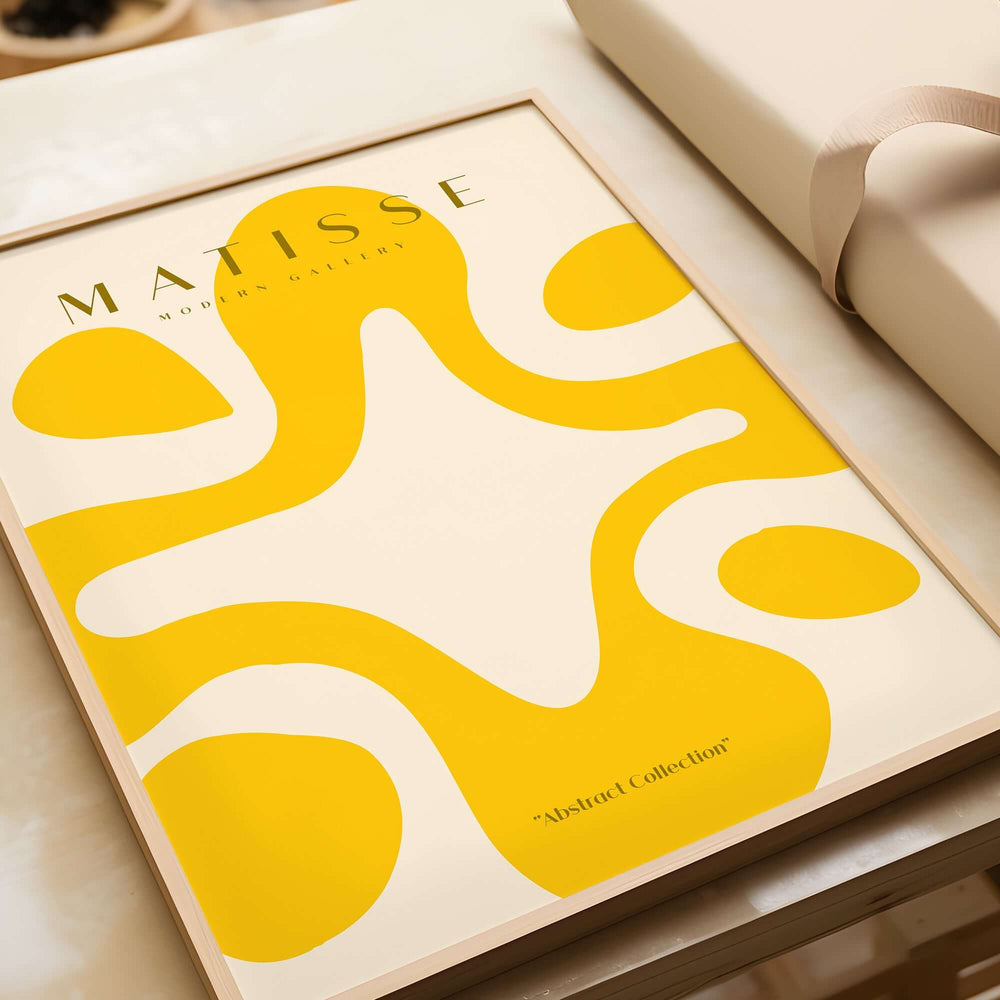Matisse Art Prints -   Yellow Abstract Fluid Shape Poster displayed on a table with a neutral background, part of the 'Abstract Collection'.
