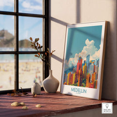 Medellin Travel Print - Colombia displayed on a wooden table near a window, showcasing vibrant cityscape art.