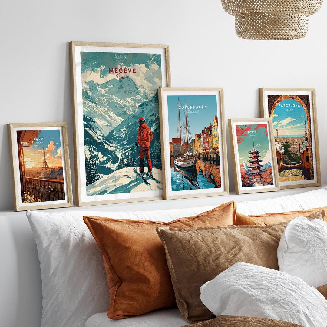 Collection of framed ski and travel posters on a wall, featuring Megève in France, with a cozy bed in the foreground.