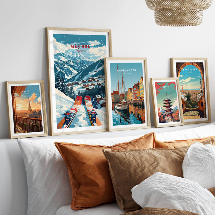 Collection of framed ski and travel posters on a white shelf above a cozy bed with pillows.