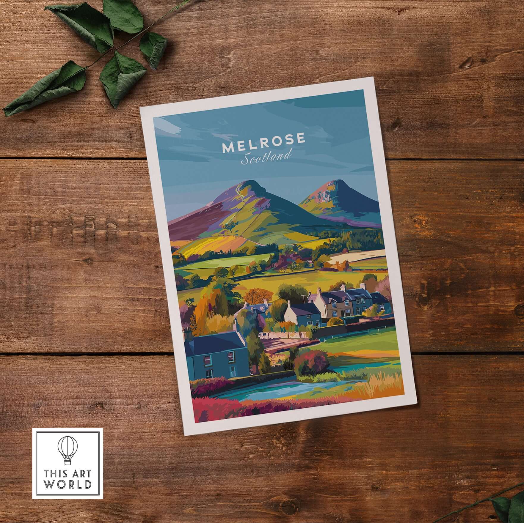 Melrose Scotland Village Travel Print Eildon Hills Poster Scottish Borders Wall Art on a wooden background.