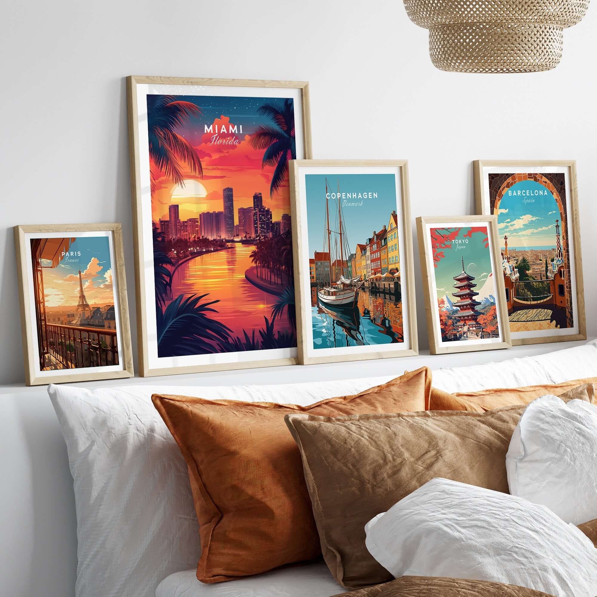 Miami Travel Print displayed among various travel posters on a cozy bed with decorative pillows.