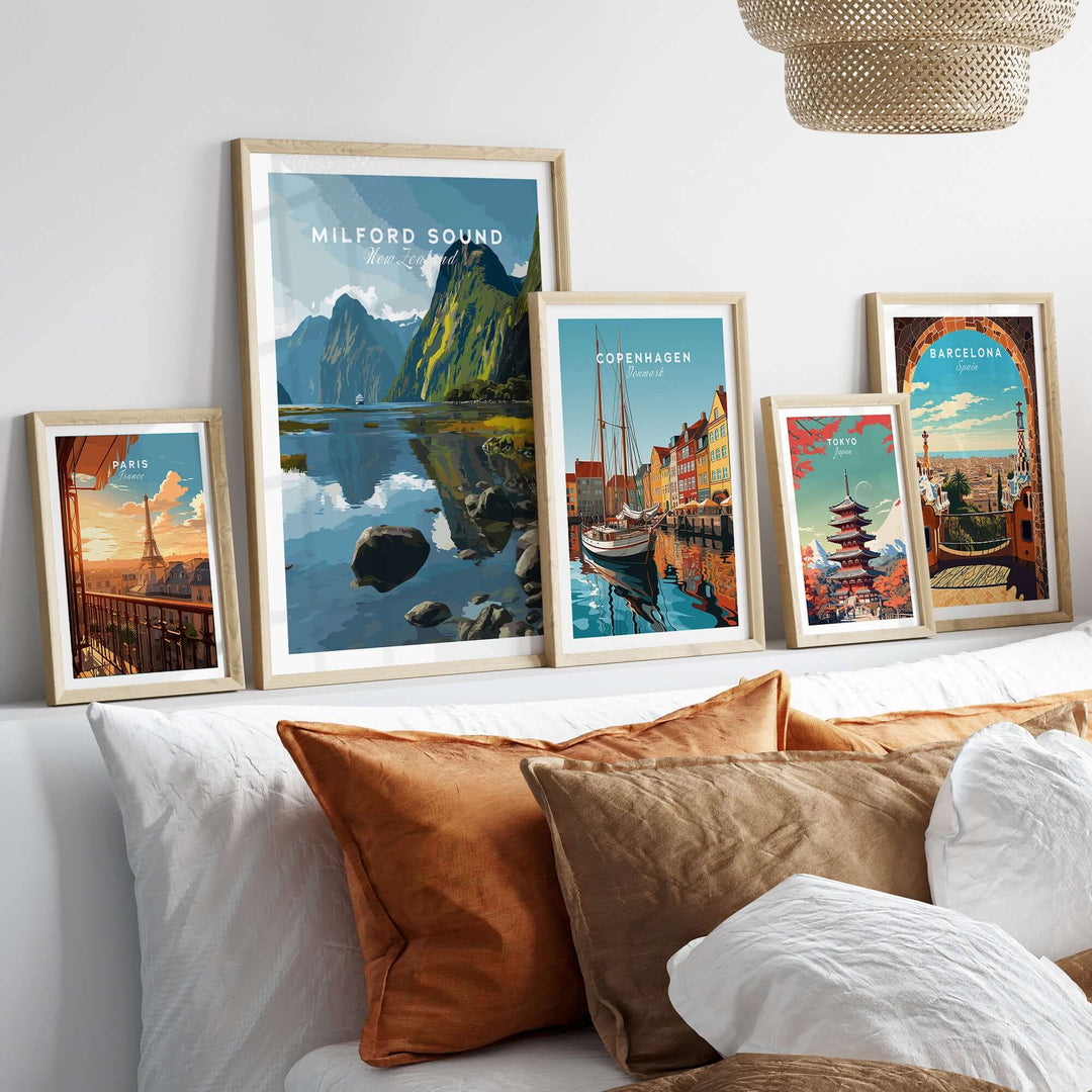 Framed travel art prints featuring Milford Sound and other scenic locations on a wall above a cozy couch.