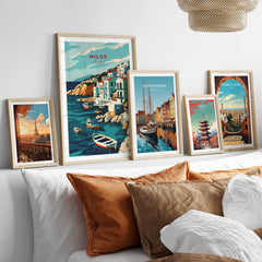 Decorative wall art featuring Milos Greece travel poster and prints from various cities, enhancing a cozy living space.