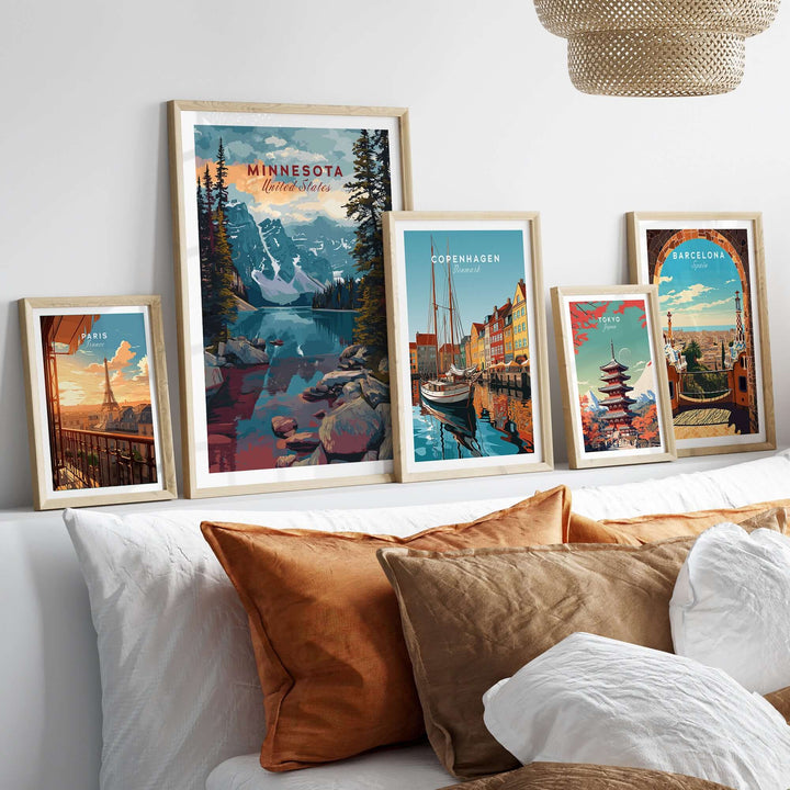 Framed Minnesota landscape poster and travel art collection on a sofa with decorative pillows.