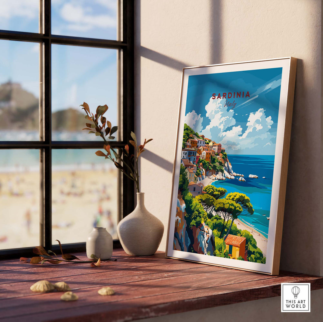 Modern Sardinia poster showcasing scenic views of Italy's coastline, displayed by a window with beach in the background.