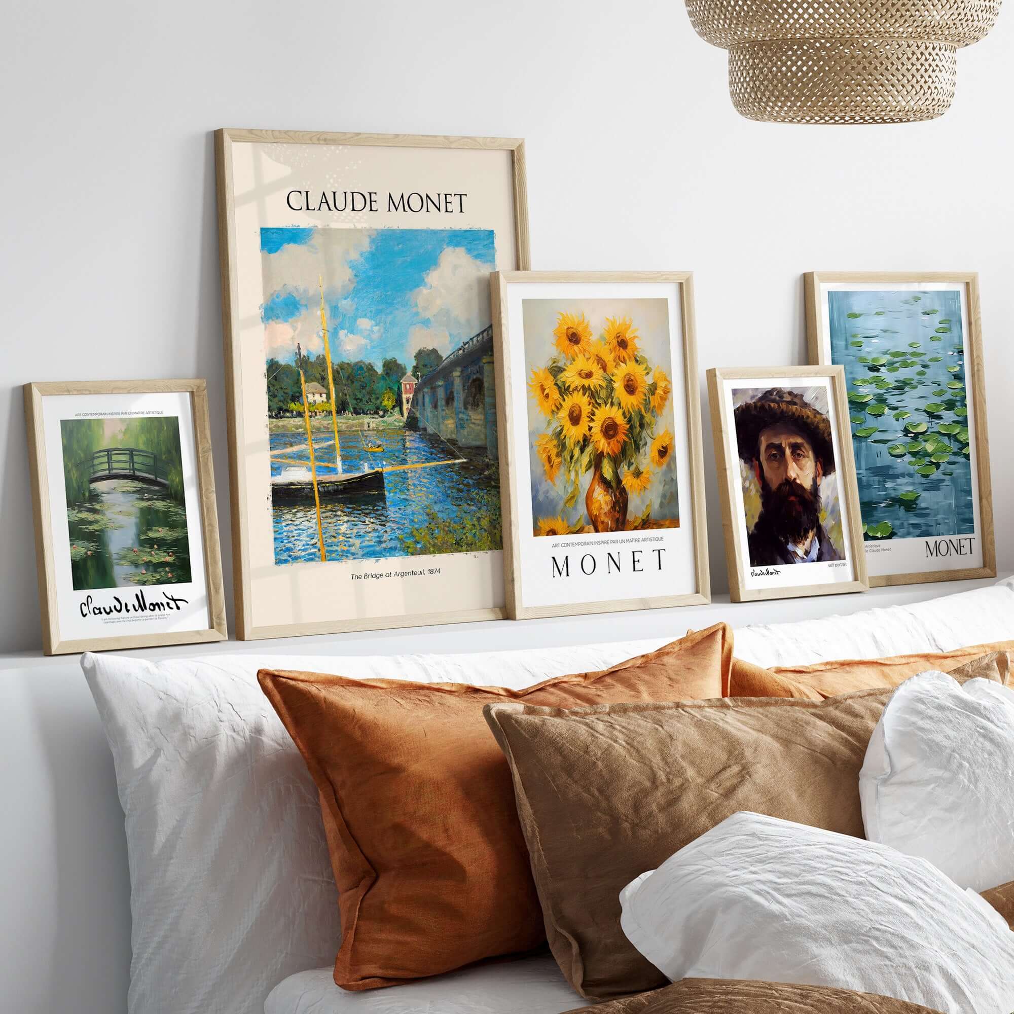 Monet The Bridge at Argenteuil Seine River Landscape Art Print Poster displayed on a bed with other Monet art prints.